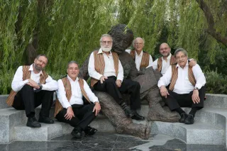 Two men sharing headphones while discussing their favorite music, reflecting emotional connection