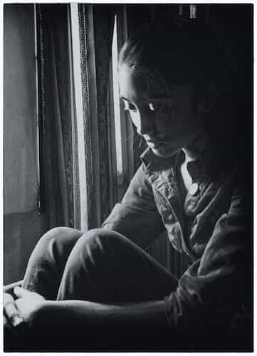 Couple sitting together but visibly emotionally distant, reflecting disconnection in love