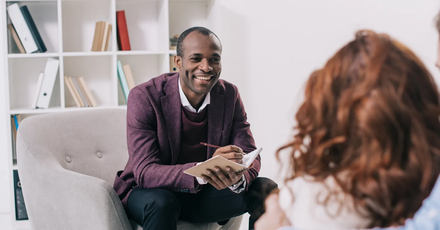Couple sitting together but appearing emotionally distant while discussing relationship signals