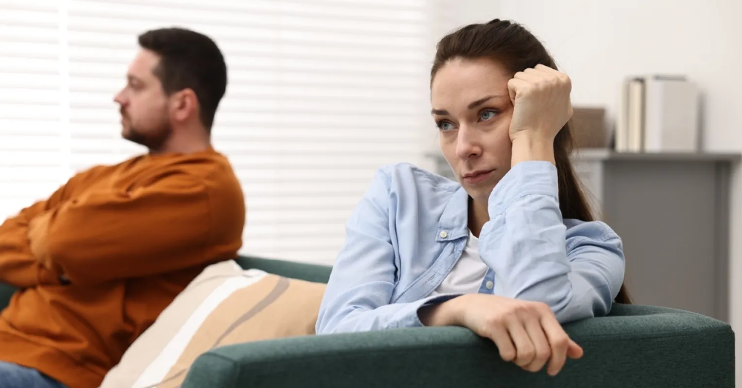 Couple sitting in silence, indicating emotional distance and potential disconnection signs.