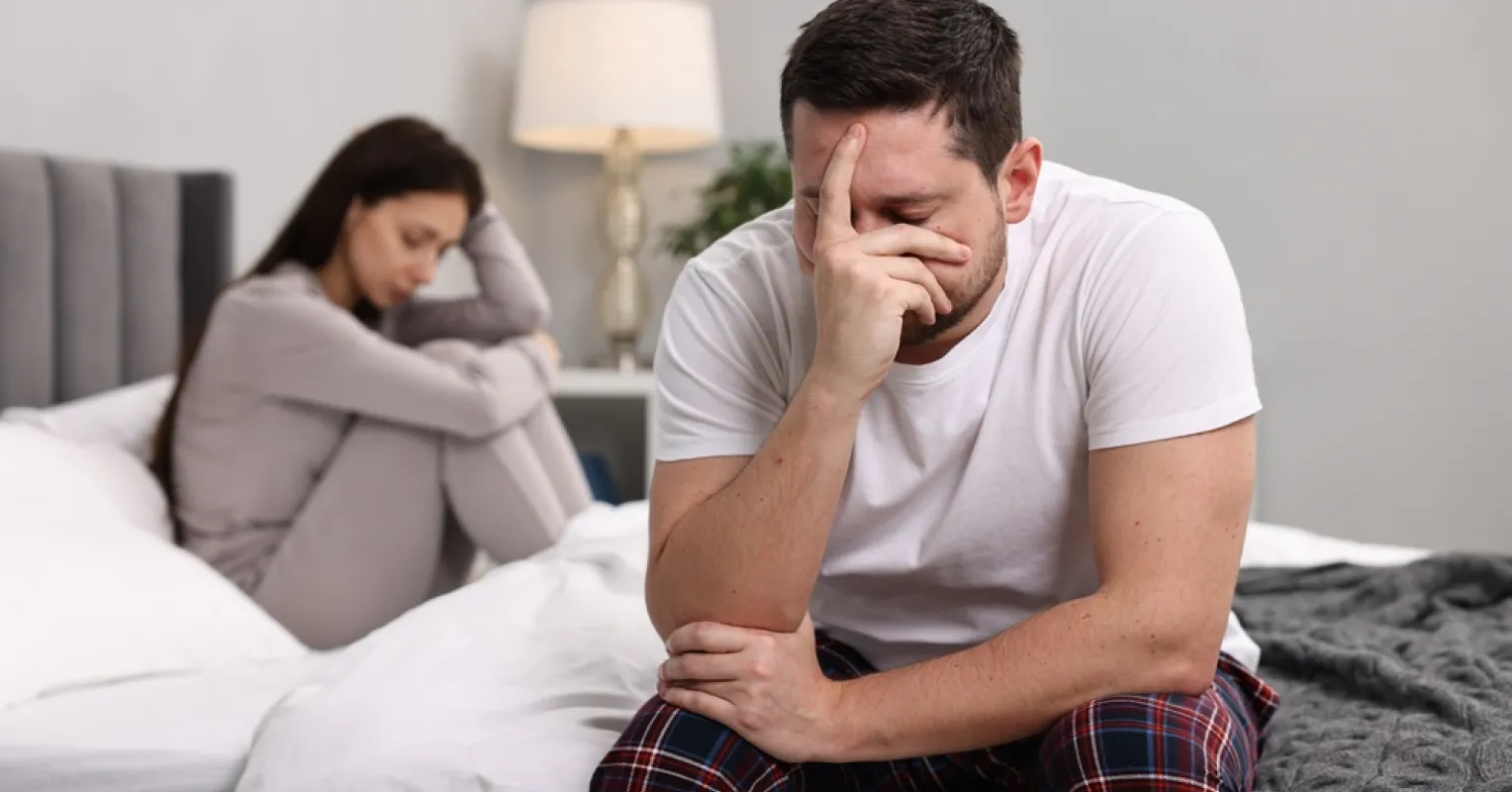 Individual reflecting on lingering feelings after a relationship ends, surrounded by emotional symbols.
