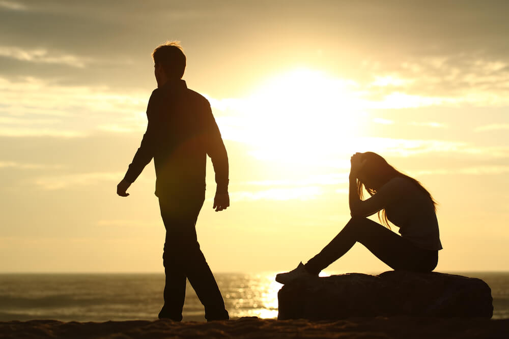 Person contemplating distant behavior while texting their crush for relationship signals