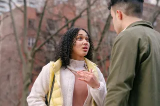 Person feeling overwhelmed while listening to their partner’s emotional needs at home.