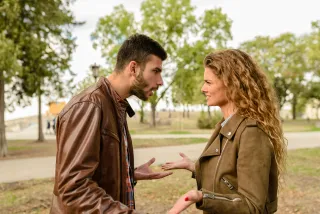 A professional woman managing her emotions while talking to a difficult colleague at work
