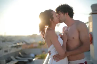 Couple sharing a passionate kiss while one feels uncertain about their connection