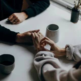 Couple sitting apart, displaying signs of emotional distance during a conversation