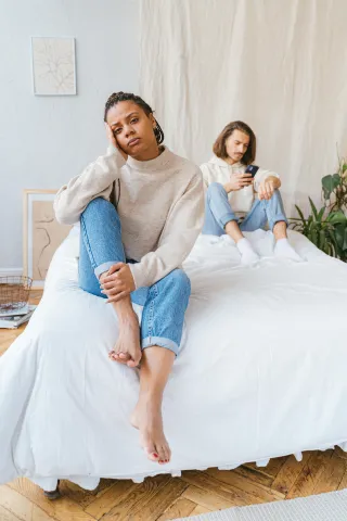 Couple sitting together in silence, experiencing emotional disconnection during intimate moments