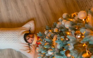 A person sitting alone at a holiday dinner table, feeling emotionally disconnected from family interactions