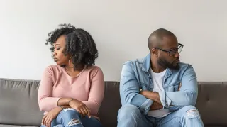 A couple sitting in silence, highlighting emotional barriers in discussing their problems