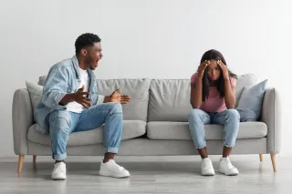 A couple sitting in silence, indicating avoidance of emotional conversations in their relationship