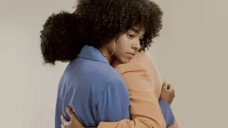 Person experiencing a sense of relief while revealing a partial truth in a conversation.