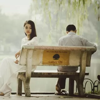 A couple sitting apart, signaling emotional distance and less affection in their relationship