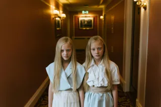 Individual reflecting on deep emotional loss while holding a their twin sibling