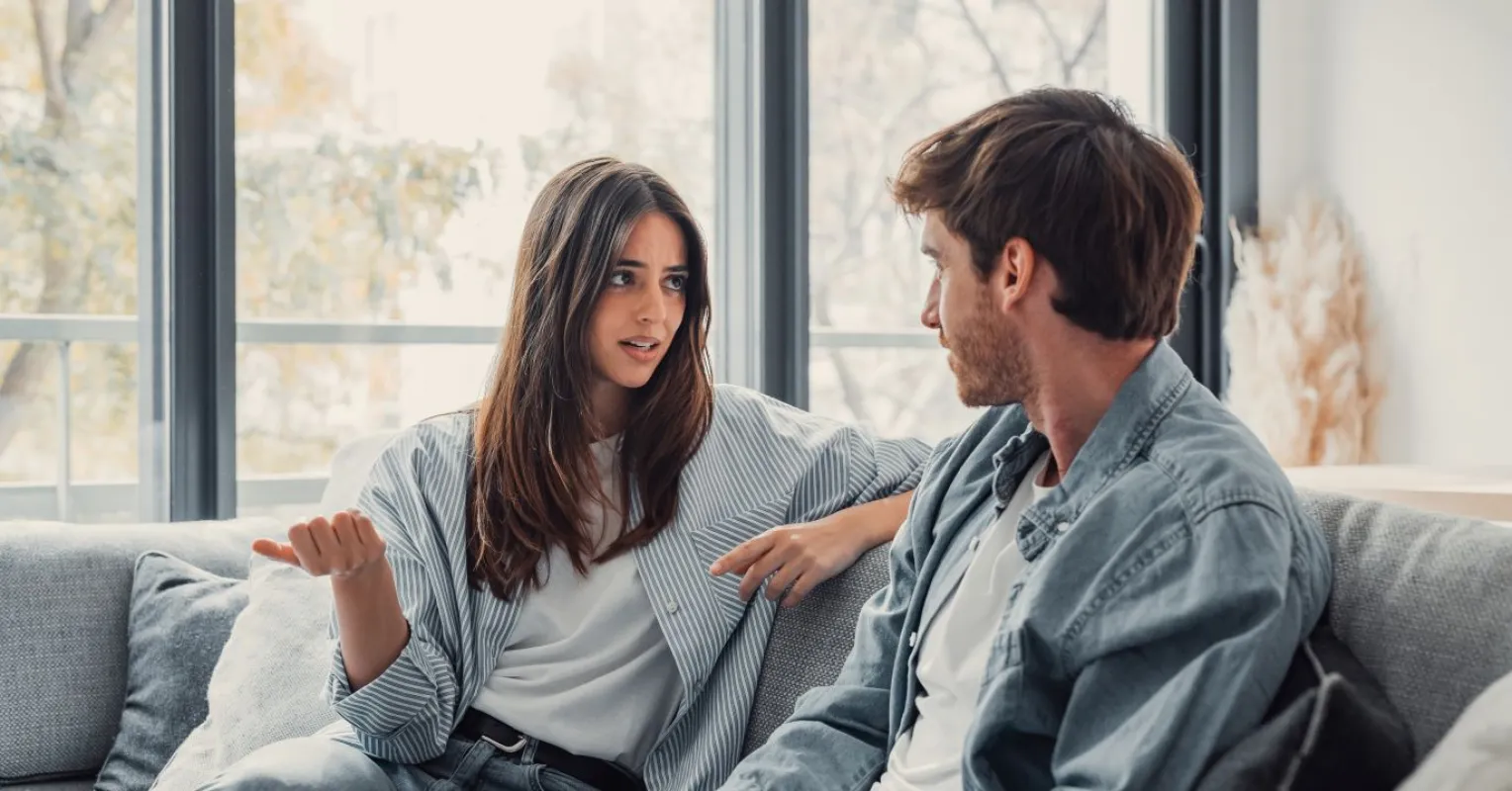 Couple avoiding eye contact while discussing difficult topics, signaling discomfort in hard conversations