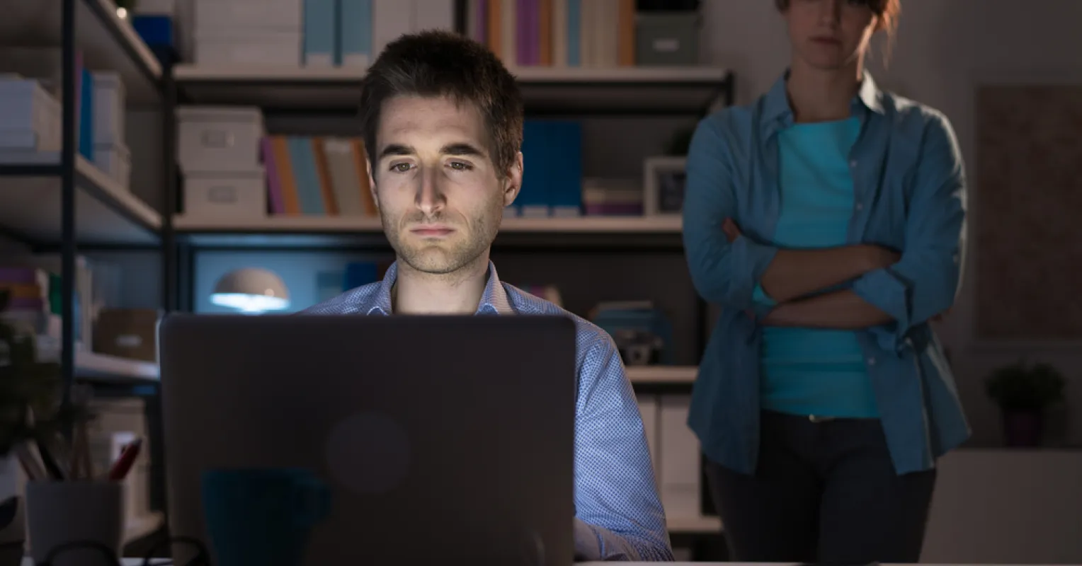 Couple experiencing emotional distance while one views pornography on a laptop
