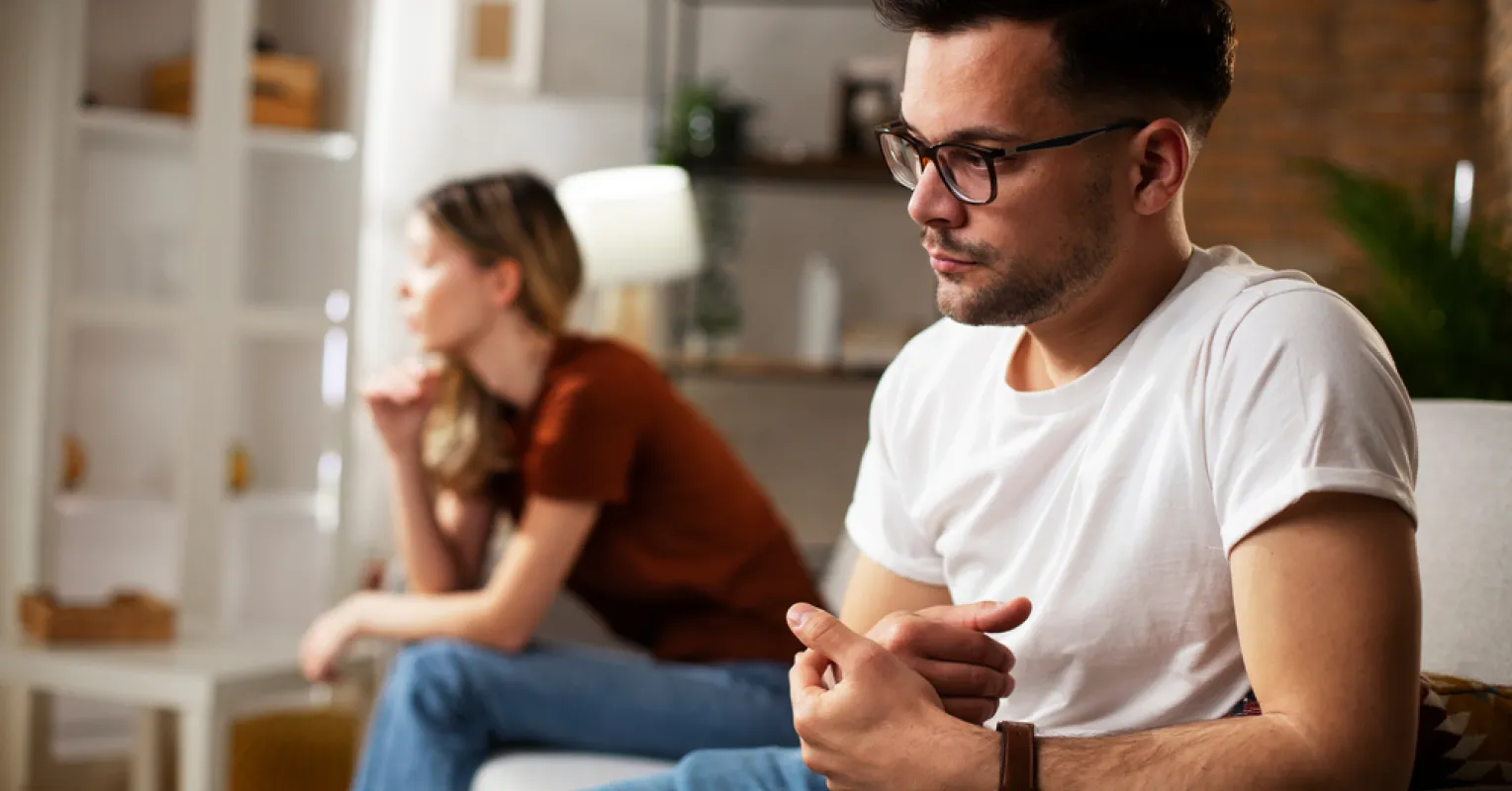 Couple sitting apart, reflecting on attachment styles during a moment of needed space