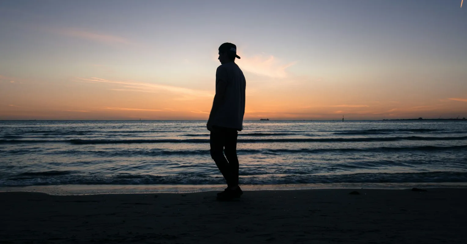 Person reminiscing about positive past experiences while feeling emotional sadness