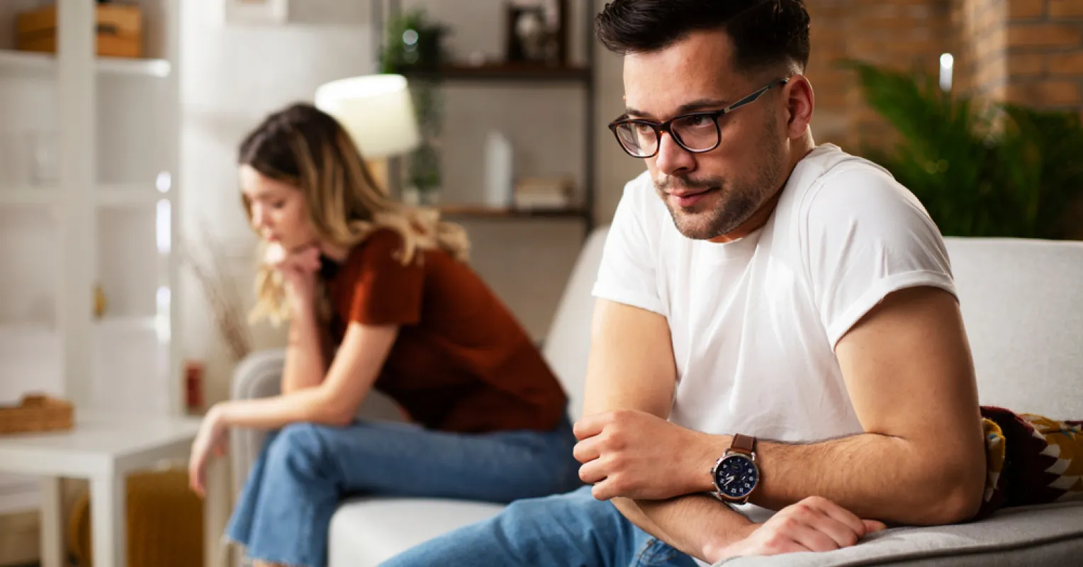 Couple sitting together but showing emotional distance during a pleasant moment