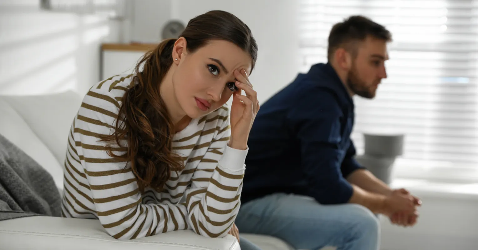 Couple sitting together, reflecting on feeling at home yet experiencing unhappiness.