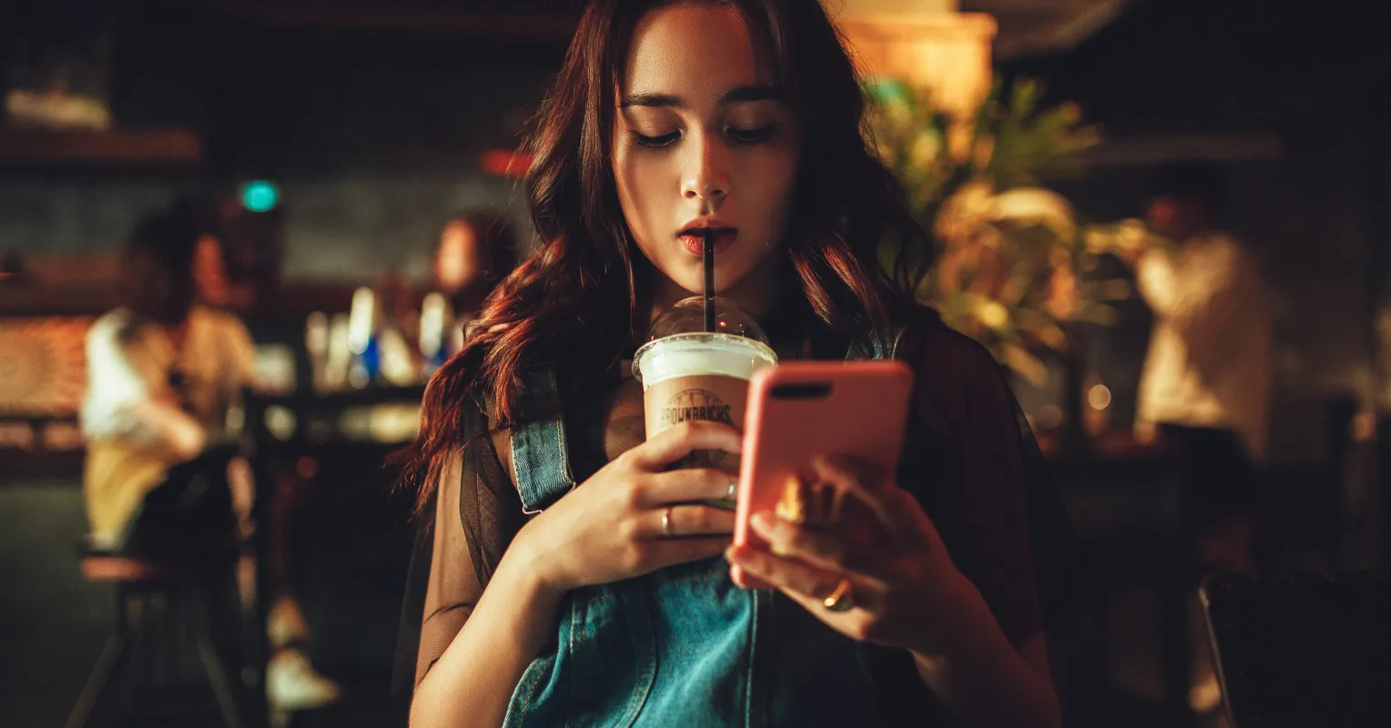 Couple sitting together, one distracted by their phone while the other feels ignored