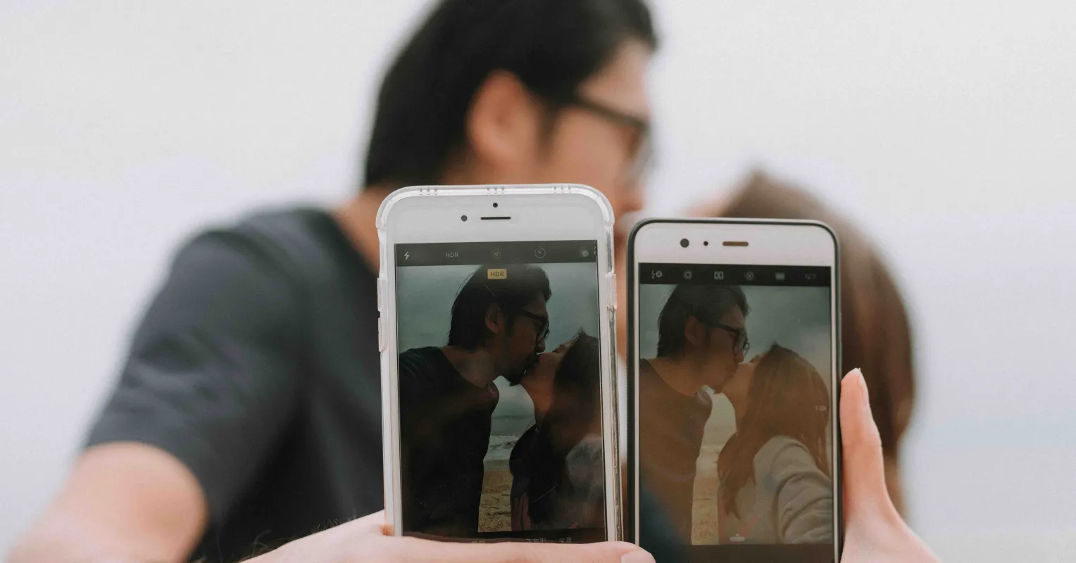 Couple sitting together, one engrossed in their phone, showing relationship signals of disconnection