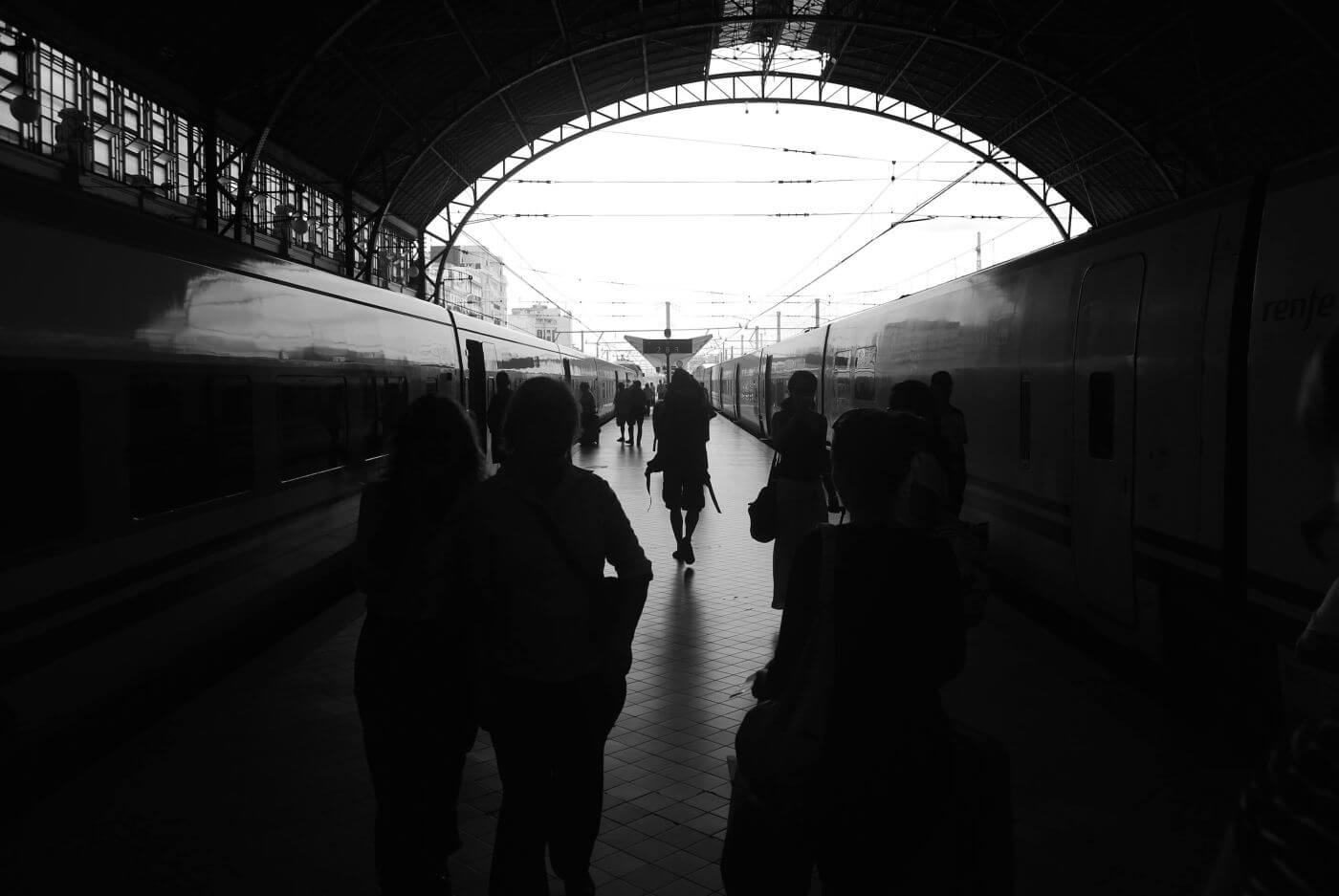 Traveler gazing out at a sunset, reflecting on emptiness after journeying