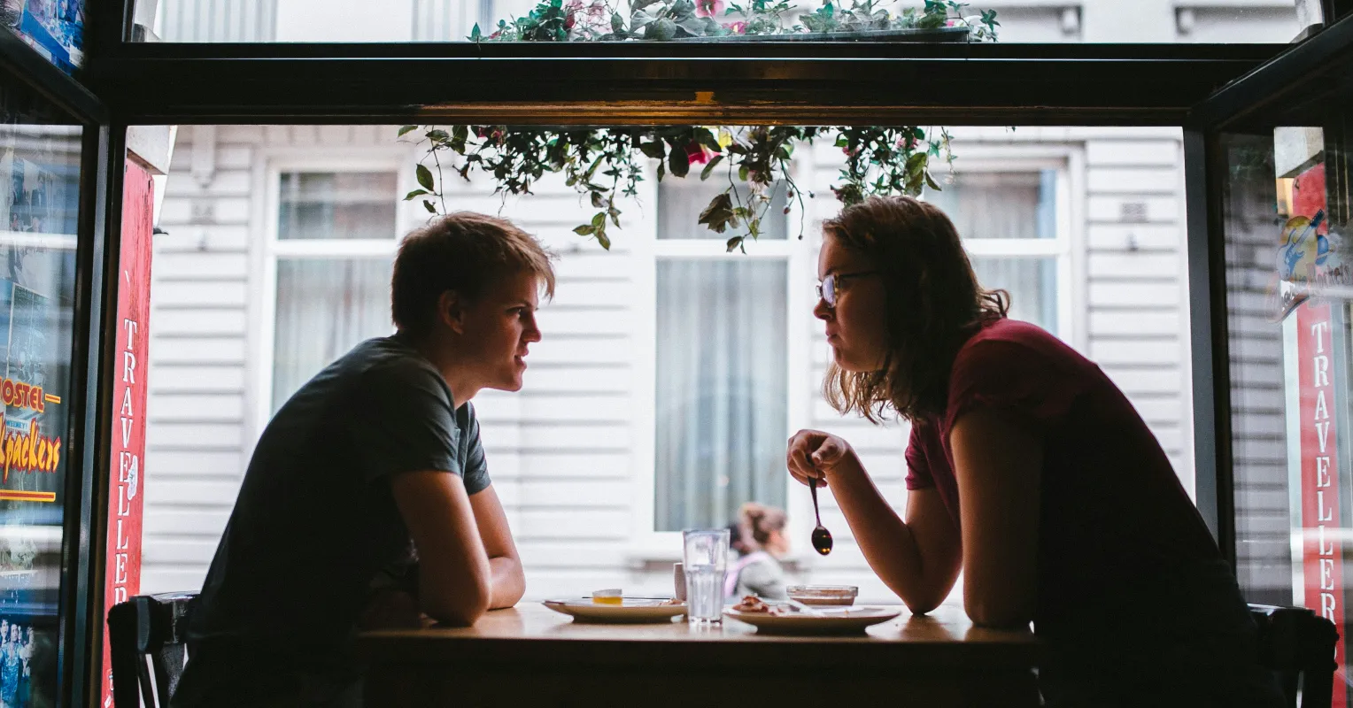Couple sitting apart, reflecting on emotions after a disagreement suggests distance in relationships.