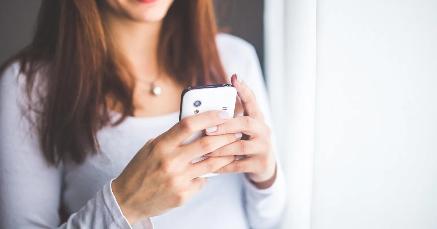 Friend feeling guilty while checking messages on a phone, reflecting on friendship signals