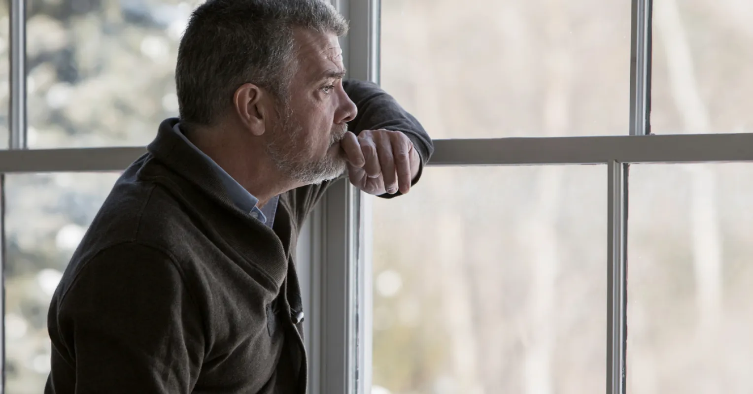 Individual looking contemplative, reflecting on why some withdraw while grieving