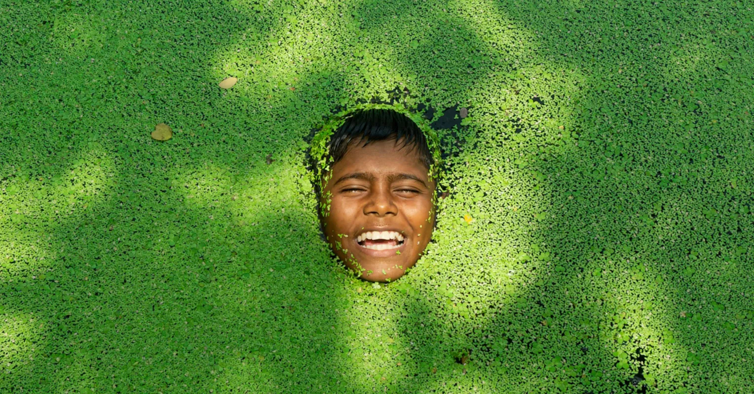 Individual smiling nervously at a gathering, reflecting stress in social settings
