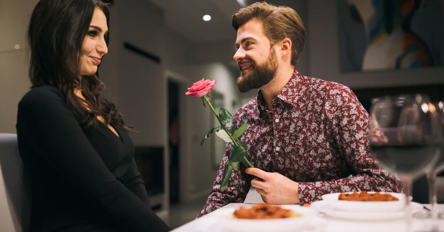 A couple sharing laughter moments, yet one appears emotionally distant despite the good date.