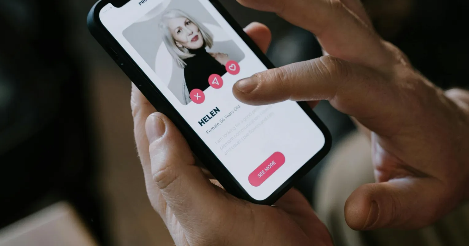 Individual contemplating their dating profile, feeling anxious about how they present online.