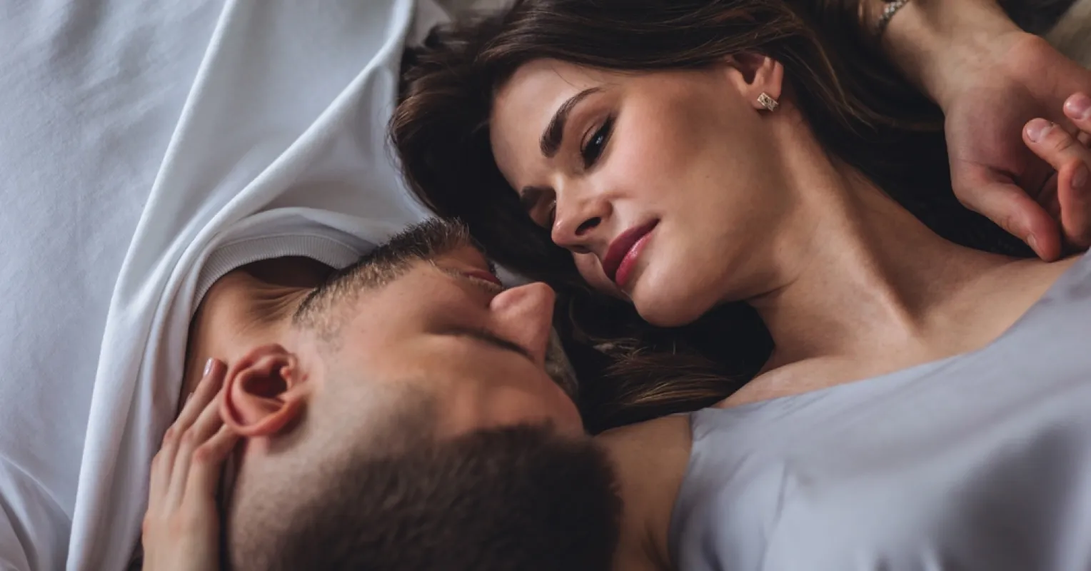 Couple experiencing emotional disconnect as one partner uses their phone after intimacy