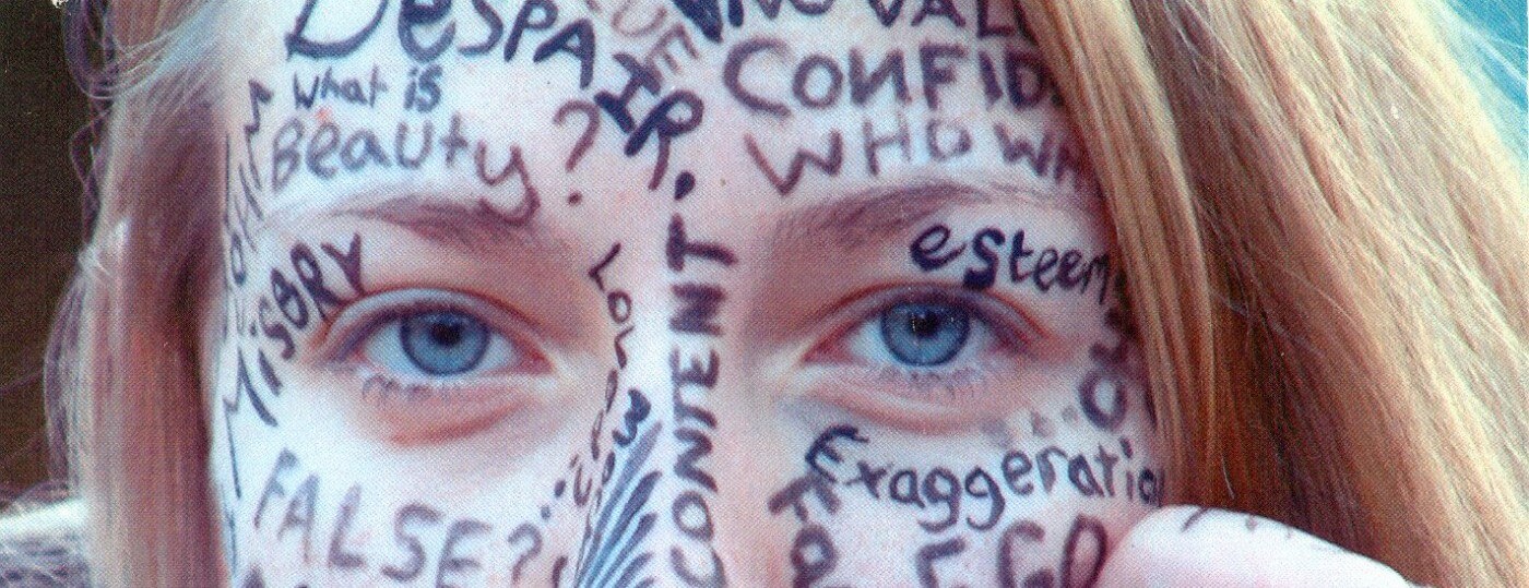 Individual reflecting on their insecurities while observing others in a social setting