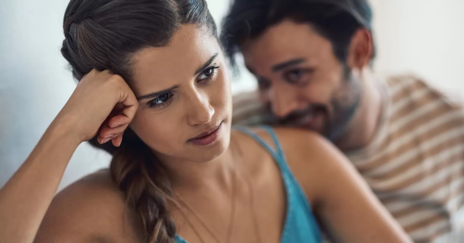 Person sitting alone, contemplating feelings as partner considers leaving, highlighting relationship signals.