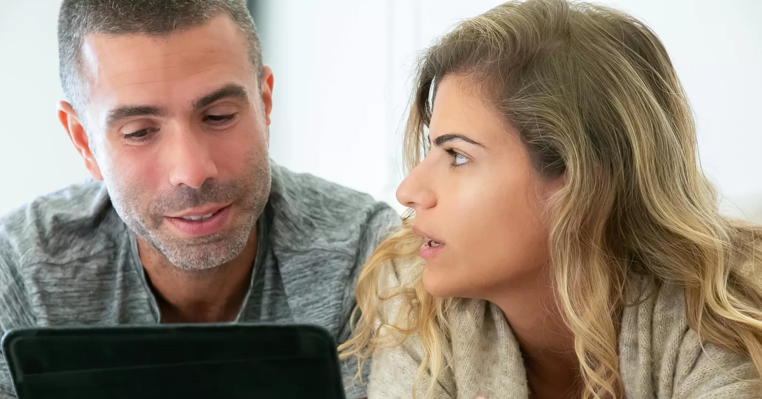 Two people engaged in conversation, with one showing subtle signs of interest while hiding their feelings.