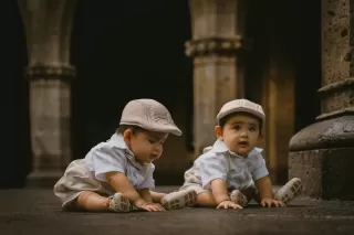 Two twins showing subtle signs of emotional distance in their body language