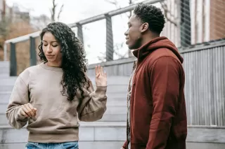 Couple in a heated discussion, highlighting overreactions during arguments and their meanings.