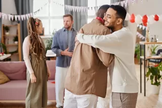 Person hesitating before hugging a male friend, reflecting on relationship signals