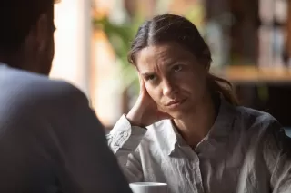 Person looking overwhelmed while attempting to communicate with their partner, feeling emotionally drained