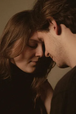 A couple sharing an intimate conversation but showing signs of emotional detachment