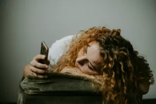 Individual engrossed in smartphone while ignoring friends at a social gathering, highlighting social dynamics.