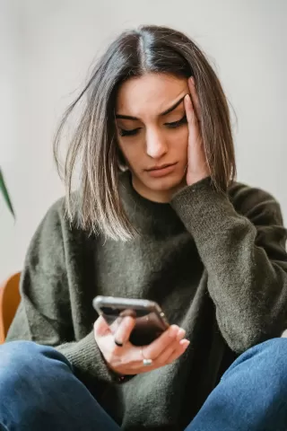 Individual contemplating rejection of potential matches on a dating app while reflecting on relationship signals