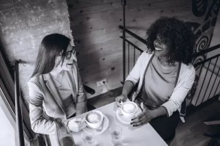 Individual contemplating sharing personal stories with friends due to social dynamics