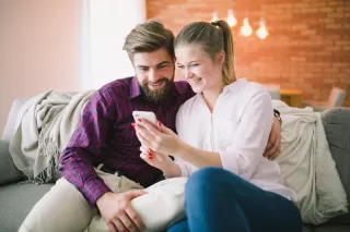 Person anxiously checking phone for a response from a date, reflecting relationship signals