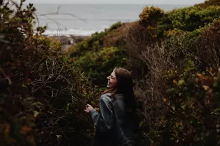 Individual sitting alone, contemplating challenges in revealing their true self to a partner
