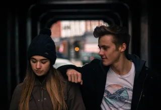 Couple discussing interests with one partner appearing disengaged and distant