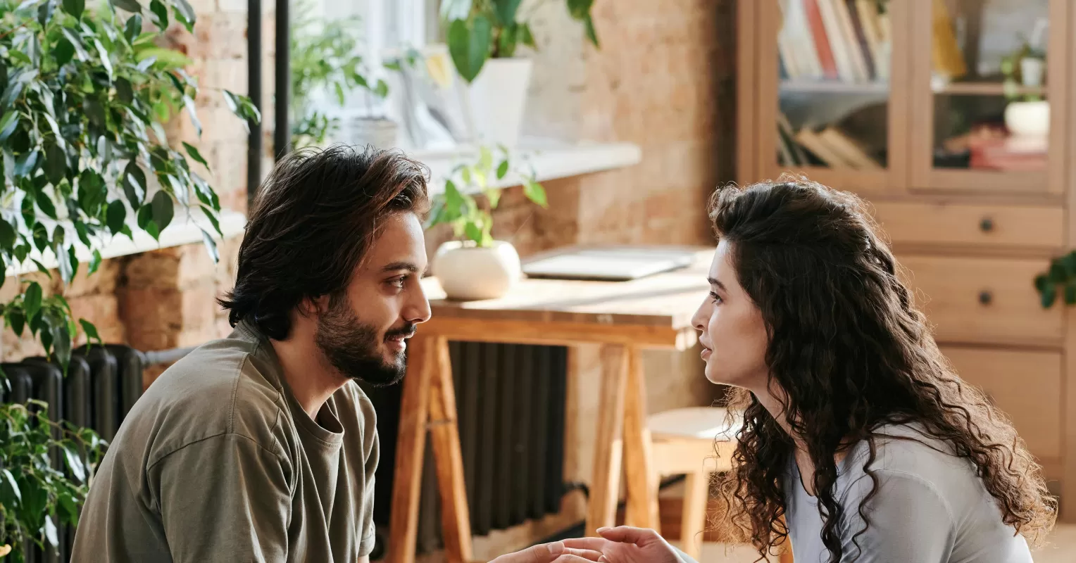 Two people discussing their feelings of jealousy in a polyamorous relationship