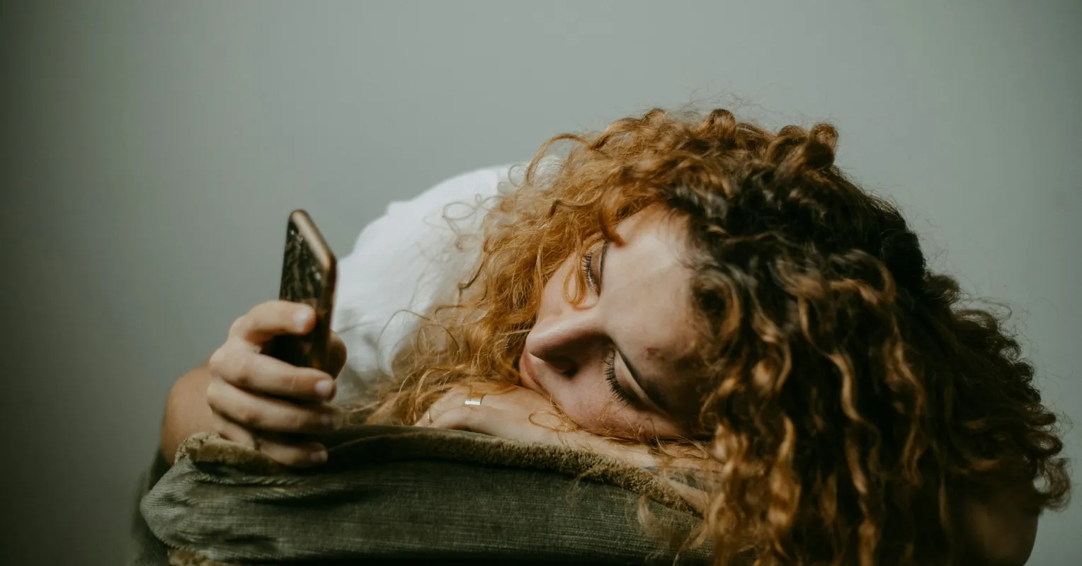 Individual engrossed in a smartphone, unaware of their surroundings, highlighting social media addiction signs.