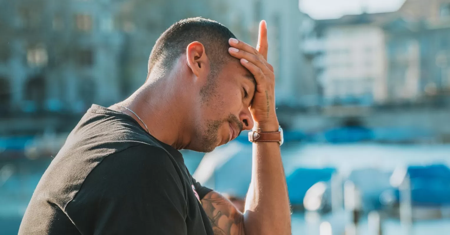 Man reflecting alone in a quiet space after a personal loss, showing emotional withdrawal.